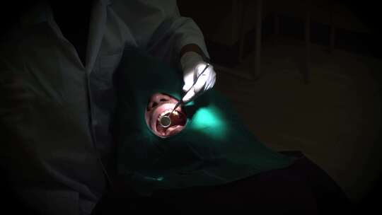 牙科医生正在检查病人口腔