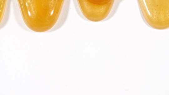 黄色化妆品凝胶液，分子气泡在白色表面流动视频素材模板下载