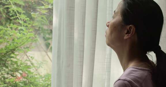 女性居家眺望窗外景色
