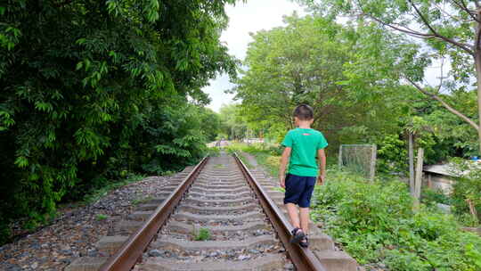 小孩走在铁路上