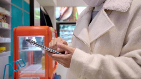 在超市使用手机自助扫码结账的女性