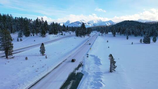 航拍汽车在积雪覆盖的山路上缓慢行驶