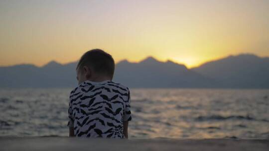 孤独的男孩坐在海边