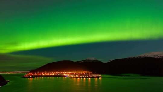夜空下极光映照城市与山脉