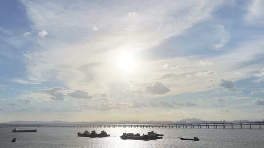 夕阳下的海面船只与桥梁景观航拍阳光下渔船