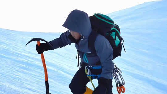 雪山登山者持冰镐攀登