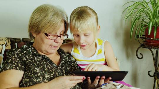 女孩和祖母玩平板电脑