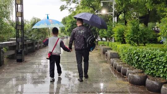 雨天父亲送儿子上学背影