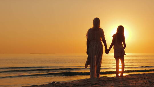 母女站在海边看美丽的日落