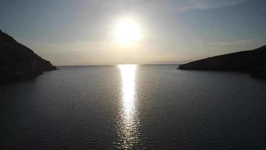 日落时海鸥飞过海湾的海水