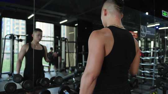 年轻男人在健身房锻炼身体面对镜子练习举重视频素材模板下载