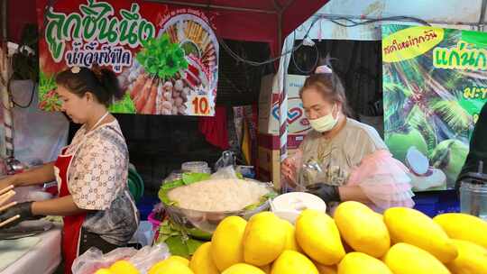 泰国清迈夜市摊位上的女性在准备食材