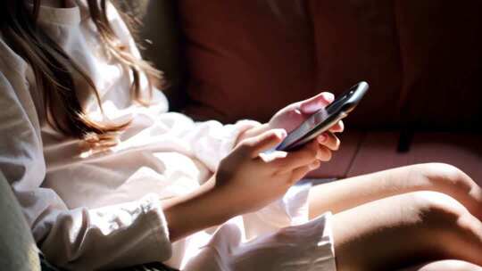 女孩坐沙发上玩手机素材