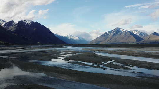 编织的冰川河流流经宽阔的山谷和新西兰的岩