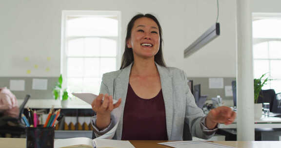 快乐的亚洲女商人在办公室有视频通话