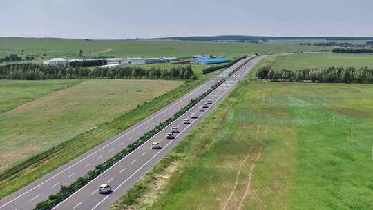 草原公路穿越车队行驶航拍