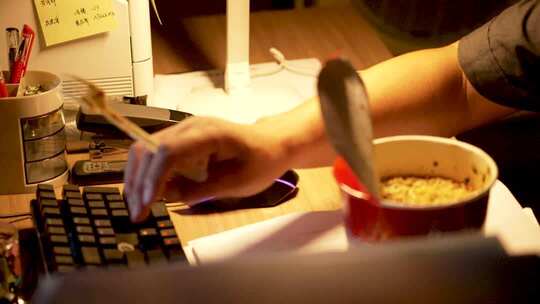 办公人员边吃泡面边敲键盘