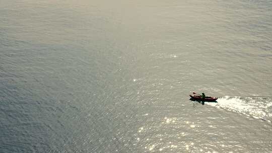 男人划船在波光粼粼的海面