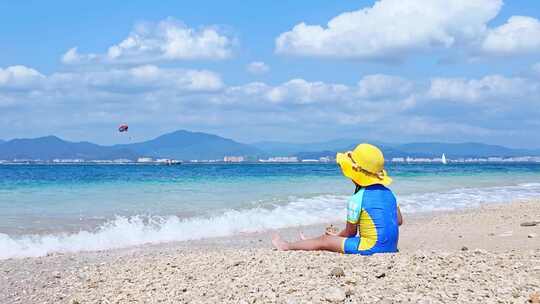 海南三亚西岛风景区小男孩坐在沙滩上治愈