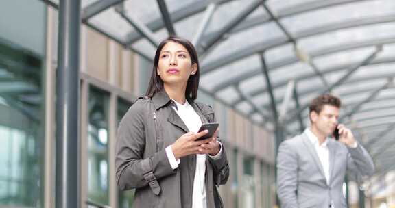 在户外建筑物附近拿着电话的女人