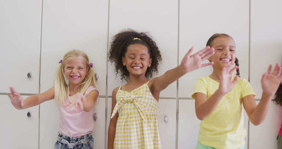 快乐的不同女孩在学校走廊向镜头挥手的视频