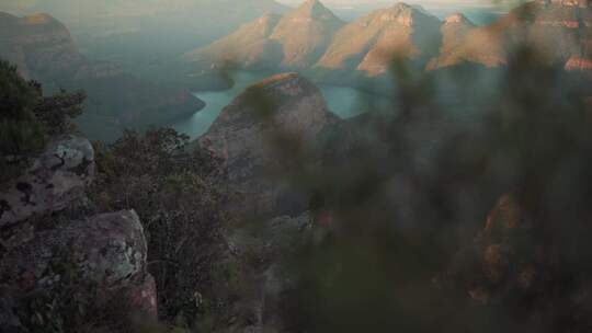 一个女人坐在悬崖岩石上欣赏山景