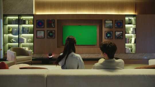 情侣夫妻在家看电视绿幕大屏