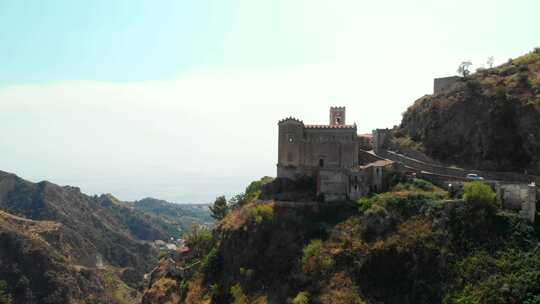 无人机从意大利西西里岛萨沃卡城堡上空升起，隐藏在山里