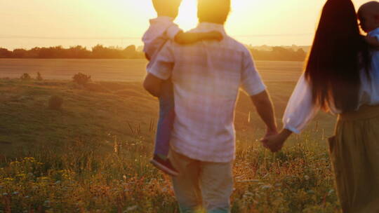 一家人走在日落时分的田野里视频素材模板下载