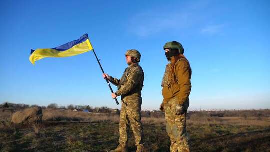 乌克兰军队士兵在日落时分站在户外，挥舞着