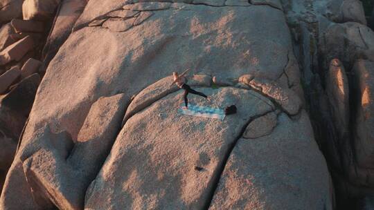 女人在岩层上做瑜伽