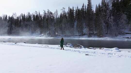 航拍新疆阿勒泰冬季喀纳斯游客在雪地上游玩