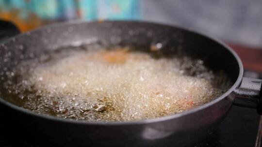 烹饪油在浅锅中沸腾的慢动作特写