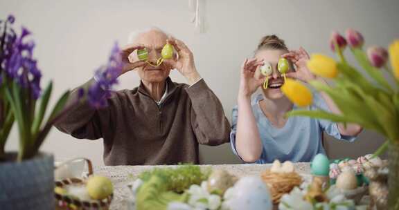 老人和女人用装饰好的鸡蛋遮住眼睛，直视镜