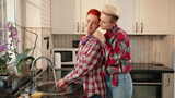 一对夫妇在温暖的厨房里快乐地一起做家务，高清在线视频素材下载