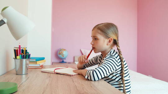 女孩坐在桌前做家庭作业