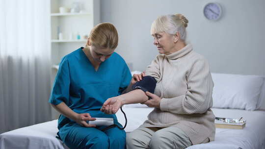 心脏病专家测量老年女性患者血压，专业医疗
