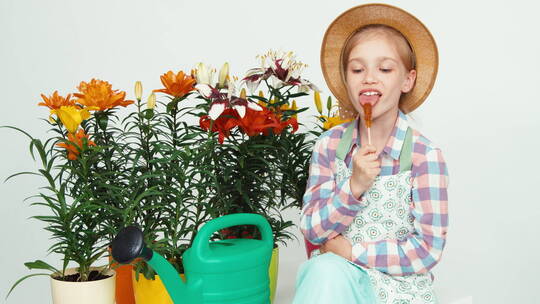 女孩戴着草帽坐在花旁边