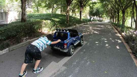 小男孩在居住小区里开电动玩具车