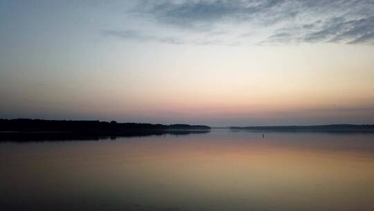 清晨平静的湖面太阳和云的倒影