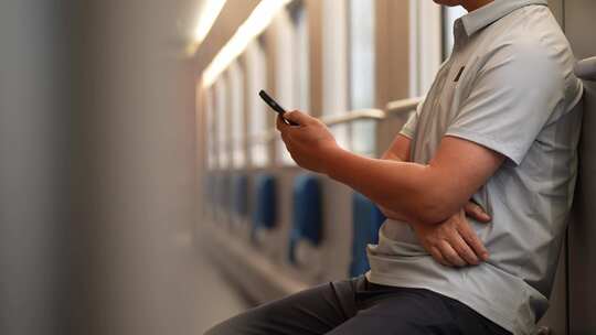 男子在卧铺火车过道上使用手机