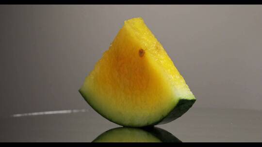 一片黄色西瓜在灰色背景上旋转360度