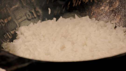 铁锅与冒热气的煮熟大米