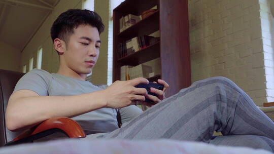 青年情侣趴在床上玩手机视频素材模板下载