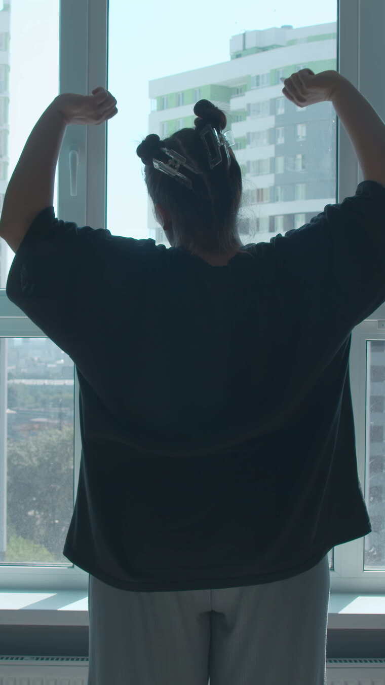 早上媒体女人透过看现代卧室里穿着休闲服的