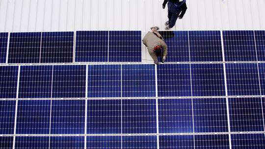 太阳能技术员在屋顶安装太阳能电池板