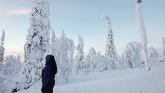 女孩下山观察美丽的白雪覆盖的冬季仙境在拉