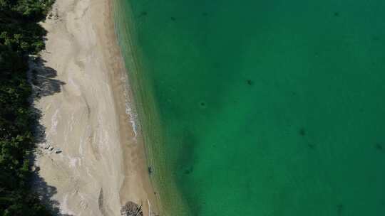 航拍海边碧绿海水和沙滩礁石风光