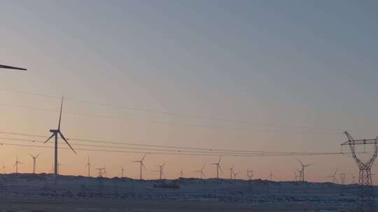 航拍新疆阿勒泰冬季雪原夕阳晚霞戈壁风电场