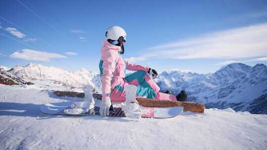 穿着滑雪服的女人坐在山顶视频素材模板下载